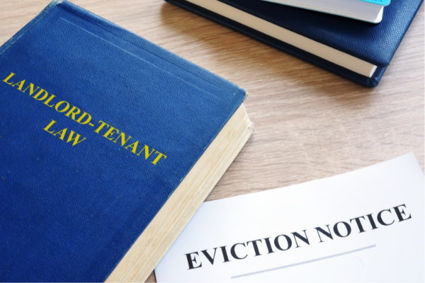 book that says 'landlord tenant law' with a paper next to it that says 'eviction notice'